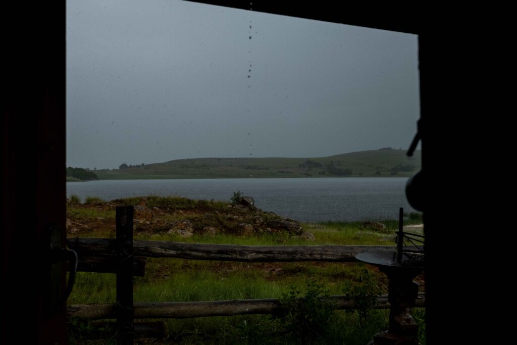 A rainstorm over a lake viewed from a cottage