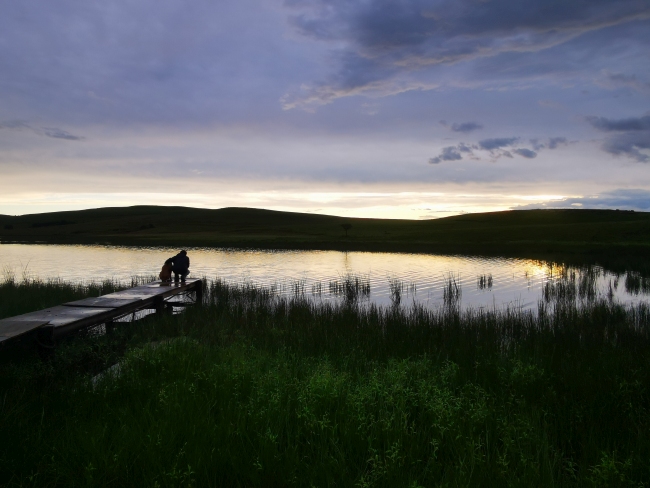 a jetty on a lake at sunset